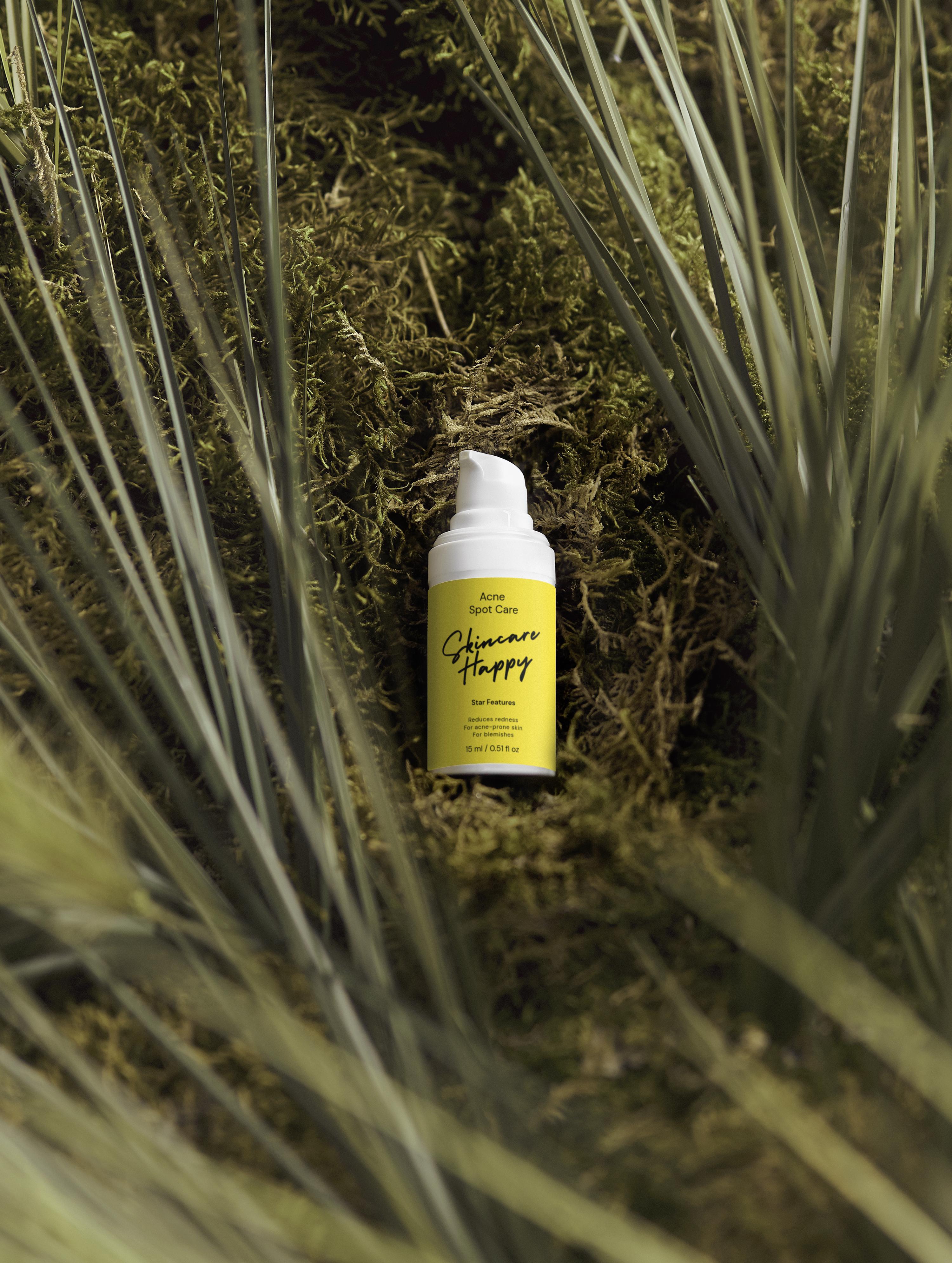 Yellow bottle with white cap on a green leafy background
