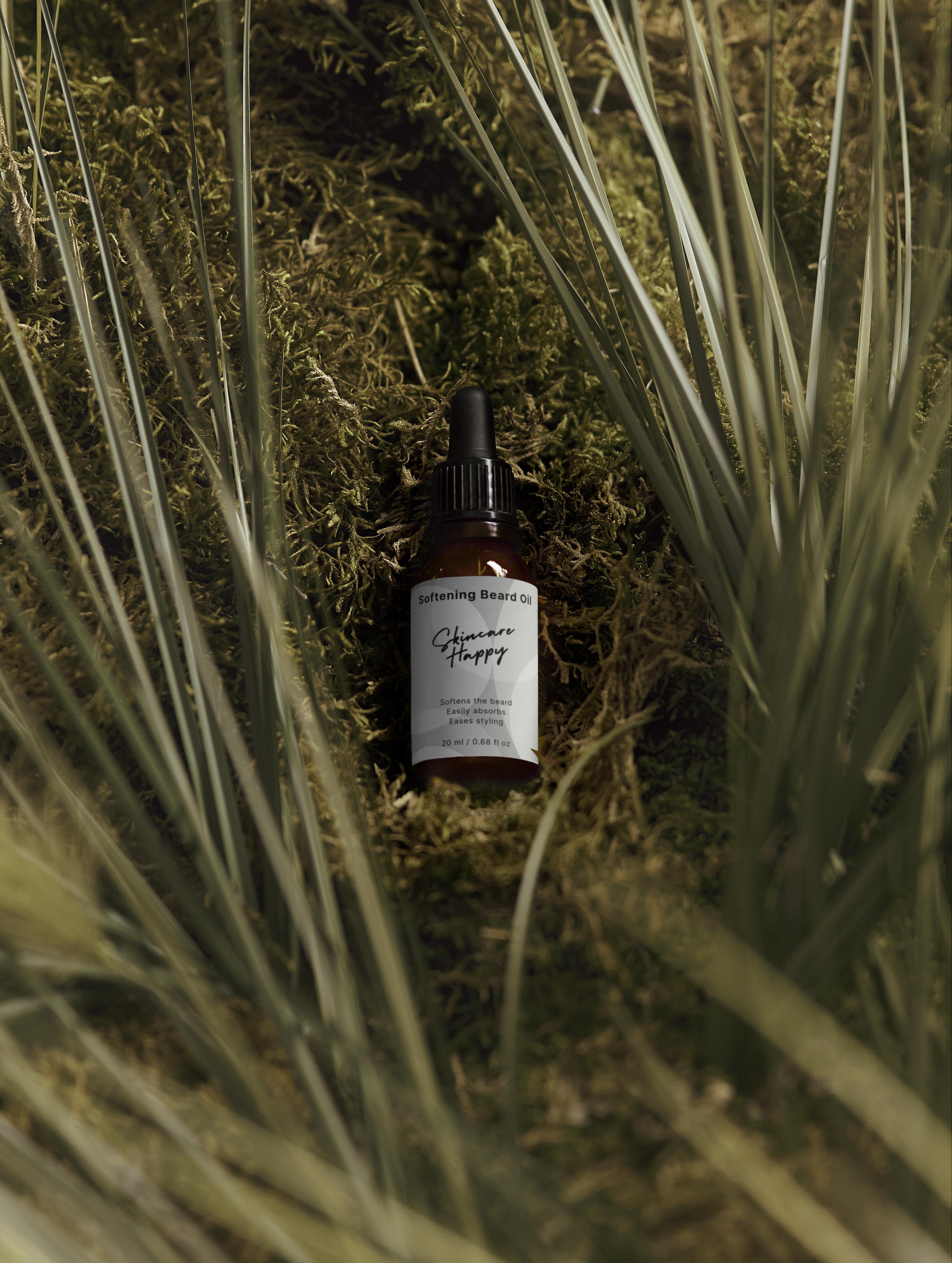 Brown bottle with dropper labeled 'Skincare Happy' on a bed of grass and moss