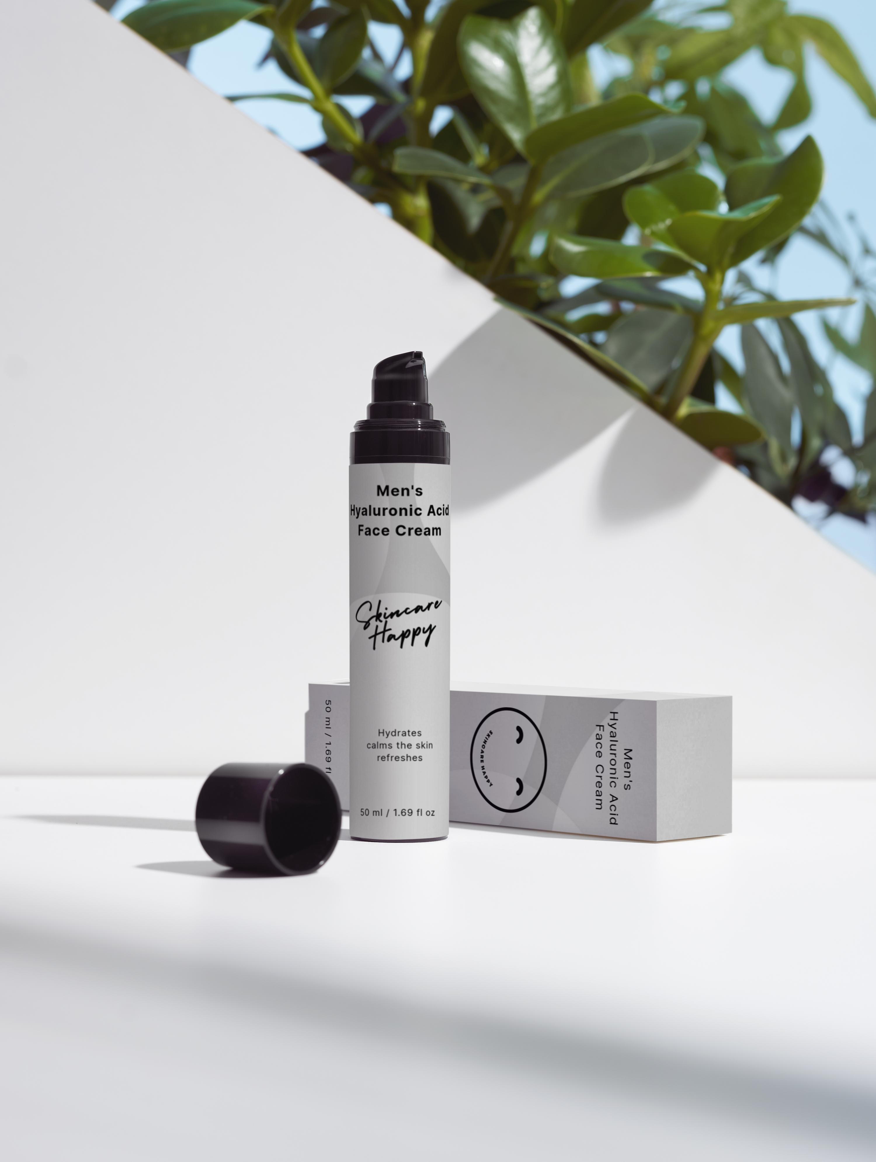 Skincare product with packaging on a white surface with greenery in the background