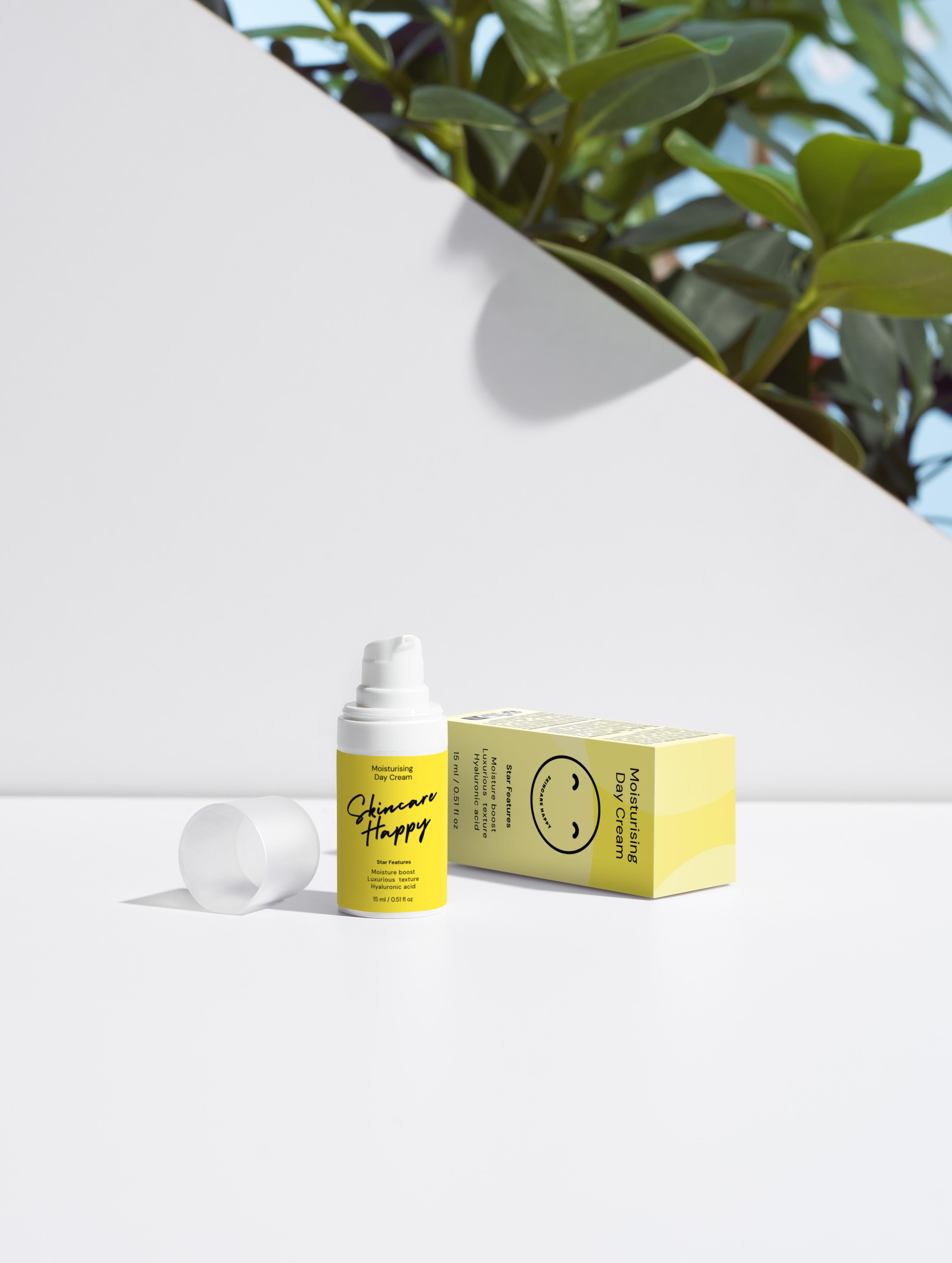 Skincare product with packaging on a white surface with greenery in the background