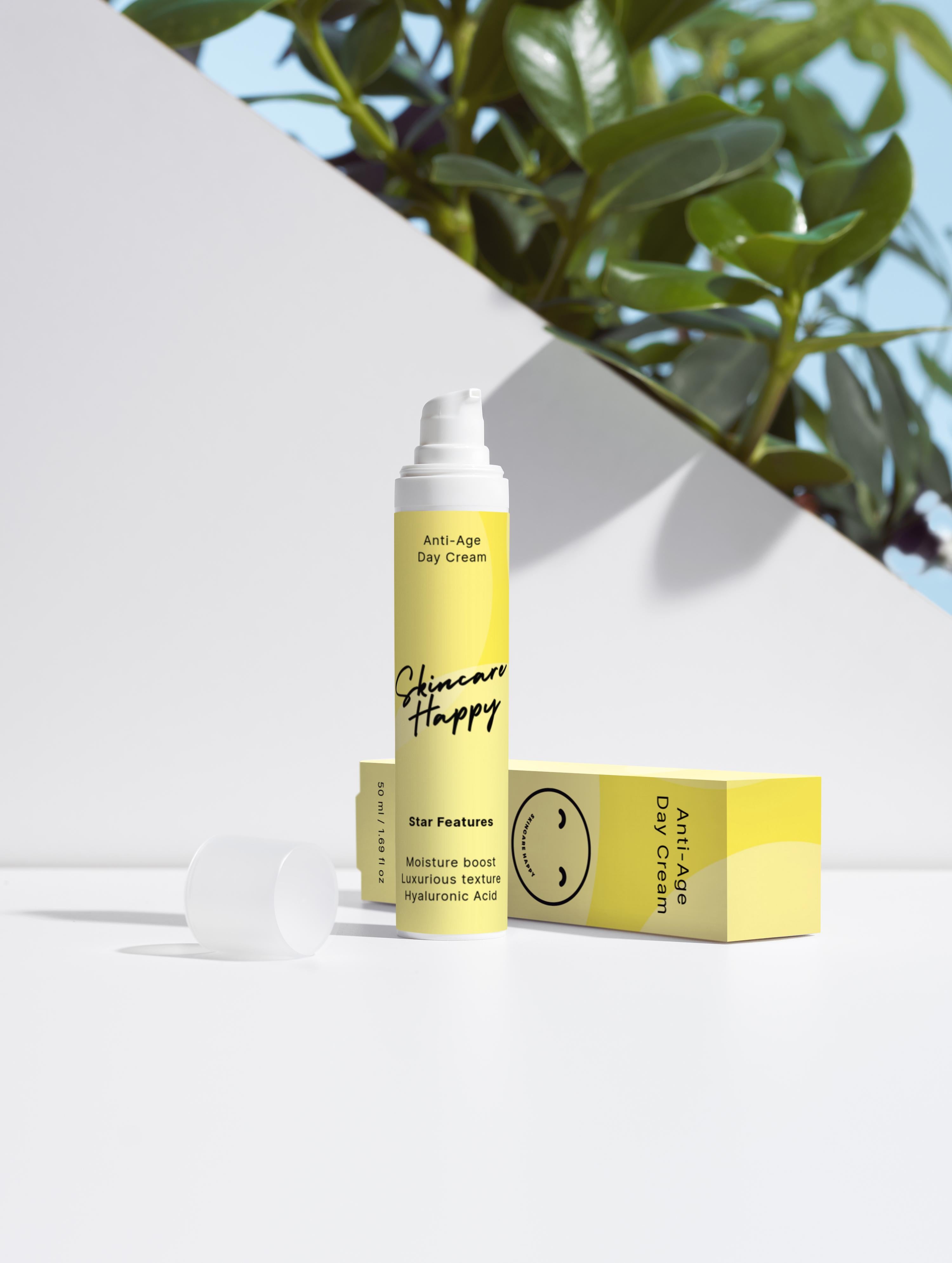 Skincare Happy anti-aging day cream with packaging on a white surface with greenery in the background