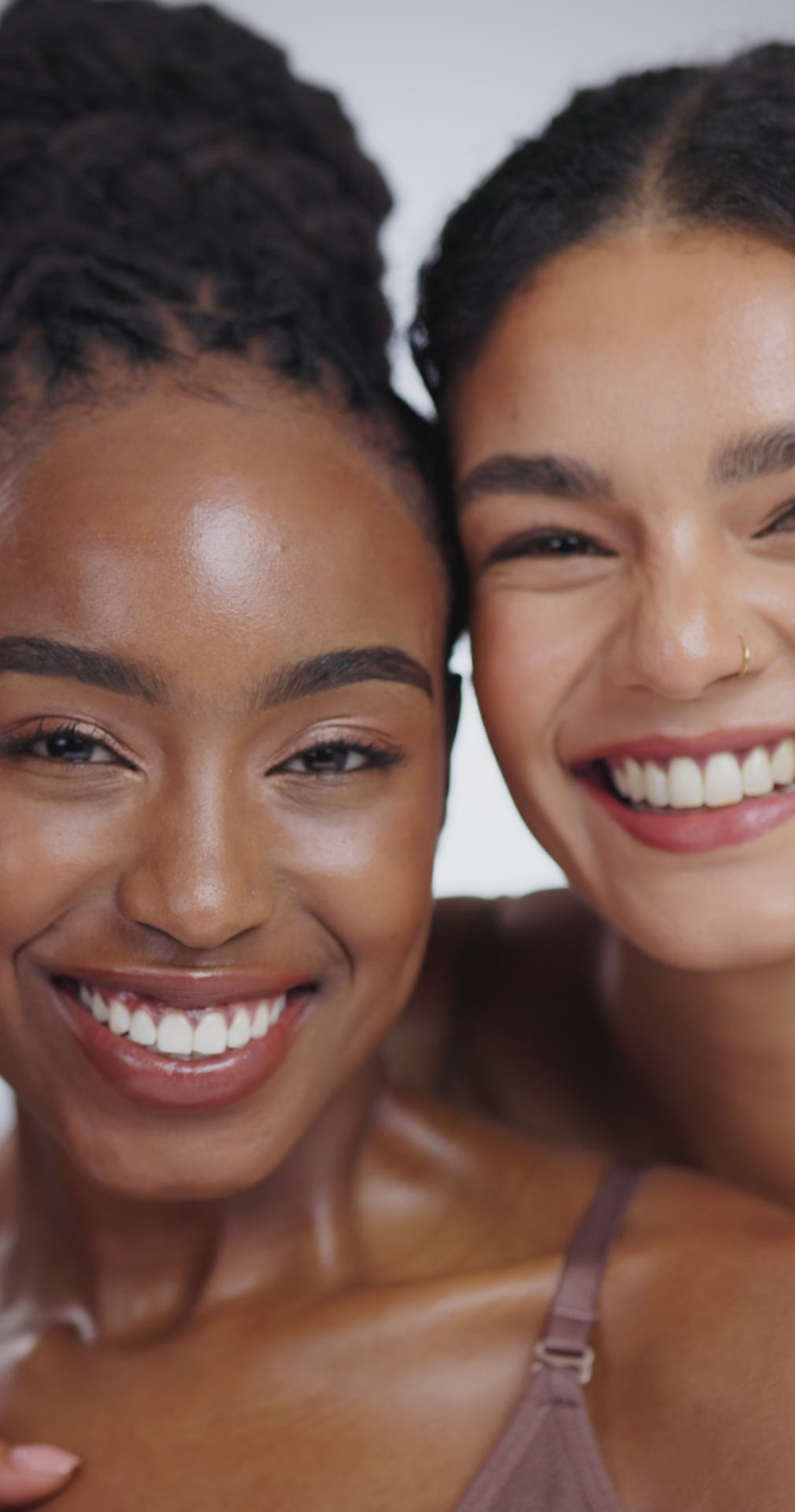 Two smiling young women with glowing skin